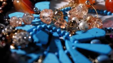 Mücevher, boncuk. Yakın plan. Döndürme. Parlak, pırıl pırıl mücevherler ve pırıl pırıl mücevherler. Makro. Bir sürü farklı renkte boncuk. çeşitli mücevherler, taş ürünleri, boncuklar.