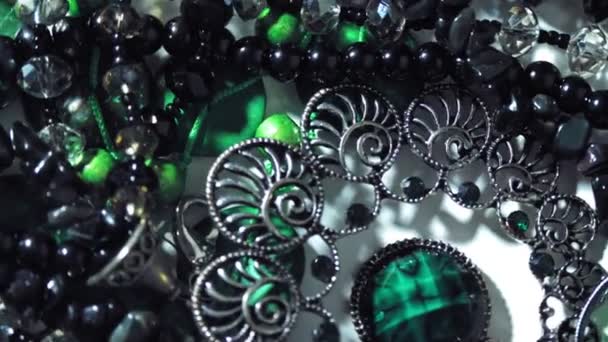 Gioielli, perline. primo piano. rotazione. Bellissimi gioielli lucenti e scintillanti con riflessi in gemme. Macro. Un sacco di perline in diversi colori. vari gioielli, prodotti in pietra, perline di malachite verde. — Video Stock