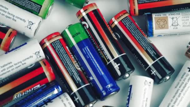 Pilhas alcalinas. close-up. rotação. Diferentes tipos de baterias giram na plataforma giratória. Muitas baterias multi-coloridas AA e AAA. vista superior. — Vídeo de Stock