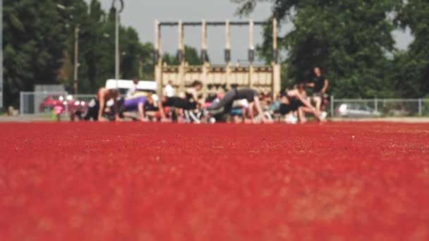 Grupowy trening fitness na zewnątrz. niewyraźne skupienie. Ludzie w ubraniach aktywnych ćwiczą razem, na boisku sportowym, w parku miejskim. boczny widok. koncepcja zdrowego stylu życia. fitness na świeżym powietrzu. sport — Wideo stockowe