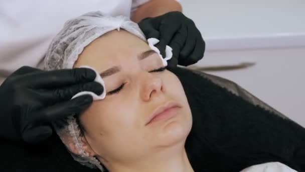 Injection de botox. injection de beauté. injections anti-âge. thérapie au botulinum. Rajeunissement du visage. Le médecin essuie le front des patients avec des tampons de coton antiseptiques, avant les injections de botox. Concept de beauté. — Video