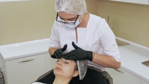 Cosmetología antienvejecimiento. masaje facial. mujer está recibiendo masaje facial para tonificar los músculos y la piel facial, drenaje linfático, en la clínica de belleza. Cuidado de la piel, procedimientos cosméticos para las mujeres. — Vídeos de Stock