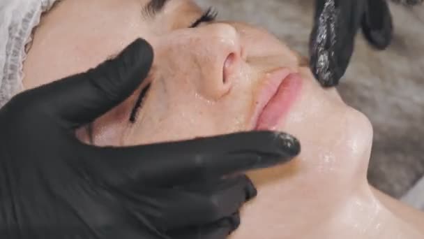 Beauty therapy. facial massage. Cosmetology skin care. close-up. woman is getting facial honey scrub massage, tonied muscles and facial skin lymphatic drainage, at beauty clinic. anti-aging procedure — Stock video