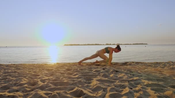 Entraînement de barre. s'étirant à l'extérieur. plage de yoga. La jeune femme sportive fait des exercices sur tapis, à la plage au coucher du soleil ou au lever du soleil. Entraînement physique à l'extérieur. Fitness, ballet, sport, yoga et — Video