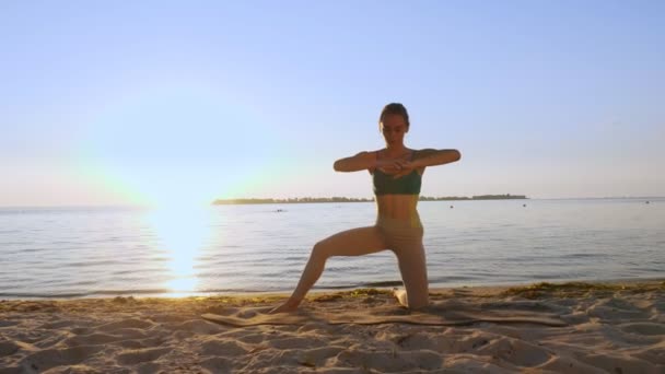 Bar antrenmanı. Açık havada uzanıyor. Yoga kumsalı. Atletik genç kadın gün batımında ya da gün doğumunda plajda minder üzerinde egzersiz yapıyor. Spor salonu açık havada. Fitness, bale, spor, yoga ve — Stok video