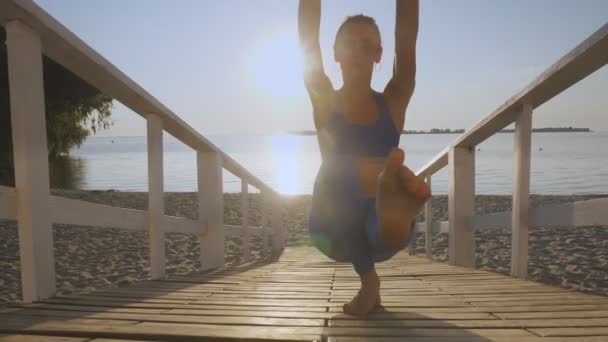 Training im Freien. Spanngurte. Training mit Gurten. Sportliche junge Frau macht Ganzkörperwiderstandsübungen mit Schlaufenseilen TRX, am Strand bei Sonnenuntergang oder Sonnenaufgang. Fitness training — Stockvideo