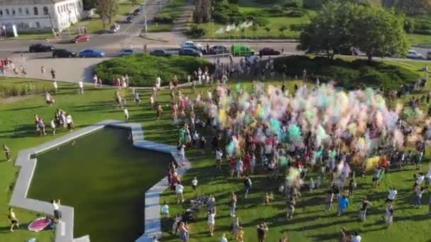 CHERKASSY, UCRÂNIA, AGOSTO 07, 2021: tintas em pó. aero. Vista aérea. Muitas pessoas se divertindo, gostando de jogar com pó de cor seca durante o festival de cores, no parque. Verão. — Vídeo de Stock