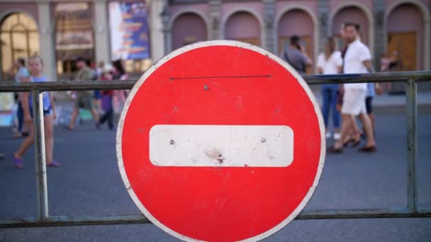 Stopp, inget inträde. stoppskylt. röd tegelsten. Stanna vägskylten. Skriv inte in tecken. närbild. Ingen vägskylt framför promenadområdet. mot bakgrund av många suddiga silhuetter av människor. — Stockvideo