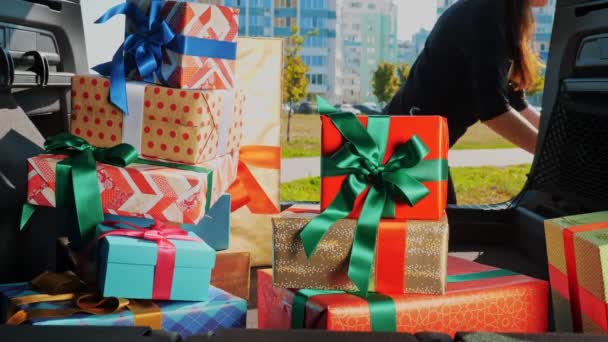 Entrega. donación, caridad. cajas de regalo en el coche. Primer plano. mujer descarga maravillosamente envuelto, cajas empacadas, del maletero del coche. vista desde el interior del coche. Regalos de Navidad. Pedido en línea. — Vídeos de Stock