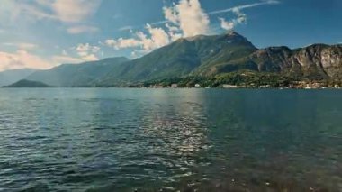 Como Gölü 'nün su yüzeyinin zaman çizelgesi ve dağ zemininde değişen ışık. İtalyan tatil köyünün dinamik görüntüleri.