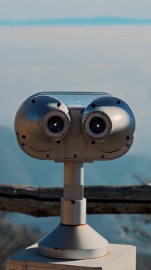 Puslu dağları ve mavi gökyüzünü gören turist dürbünlerine yakın çekim.