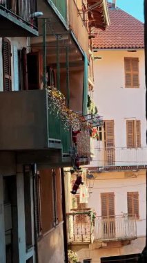 Tarihi binanın üzerinde yeşil Noel çelenkleriyle süslenmiş tahta balkon. İtalyan şehrinde geleneksel şenlik cephesi dekorasyonu.