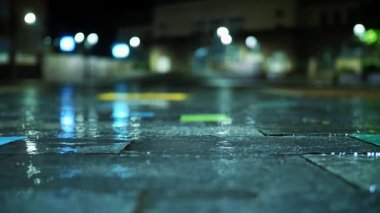 Şiddetli bir yağmur fırtınası sırasında şehir yolunu su bastı. Şehir ışıklarının asfalttaki derin sulardaki yansımaları..