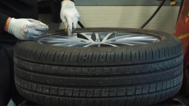 Tamirhanedeki profesyonel hortumla araba lastiği basıncını arttırıyorum. Araç bakımı ve güvenlik hizmeti kavramı.