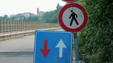 Kırmızı ve beyaz okları olan mavi trafik levhası. Bir dağ köprüsündeki yol çalışma bölgesinde öncelik işaretine yakın çekim.