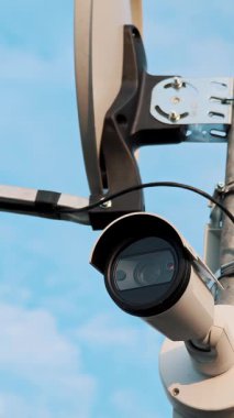 Aşağıya bakan bir CCTV güvenlik kamerası merceğinin aşırı dikey yakın çekimi. Mahremiyet ve gözetim kavramı.