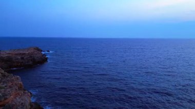 Kız, elleri ile kalp hareketi yapıyor okyanusun üzerinde batan güneşi yakalıyor, sağlığını ve farkındalığını arttırıyor. İHA 'nın üzerinden ters uçuş yap 