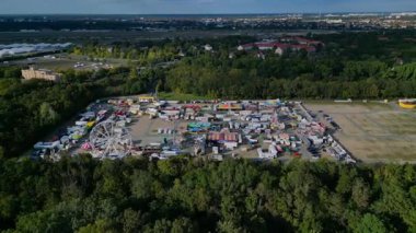 Berlin lunaparkında bir dönme dolap, lunapark gezileri ve hava perspektifinden çeşitli tezgahlar var. Hız rampası hiper hareket hızlandırılmış daire drone görüntüsü 