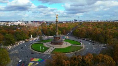 Berlins Zafer Sütunu Goldelse 17 Haziran Sokağı 'nda sonbaharda arka planda şehir silueti ile ayakta duruyor. Hız rampası hiper hareket zaman aşımı. panorama yörünge dronu 