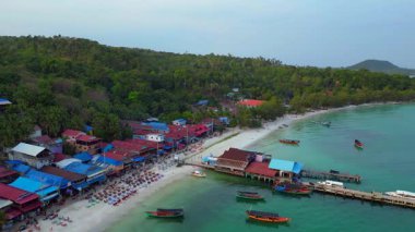 Güneydoğu Asya 'da bir körfezde, bungalovları, rıhtımları ve ahşap tekneleri olan Koh Rong adası köyü. panorama genel görünüm dronu 
