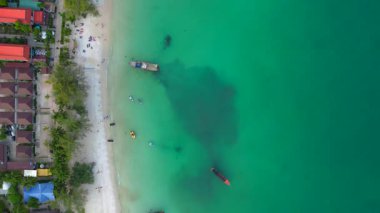 Güneydoğu Asya 'da bir körfezde, bungalovları, rıhtımları ve ahşap tekneleri olan Koh Rong adası köyü. dikey kuş bakışı dron 