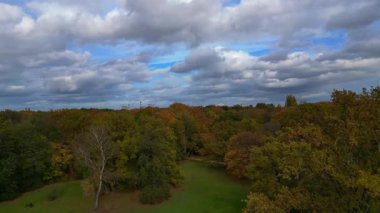 Bulutlu gökyüzünün altındaki Tiergarten Parkı 'nın sonbahar renkleriyle Berlin şehri. İHA yükseltiliyor 