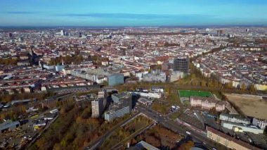 Berlin 'in berrak bir gökyüzü altında geniş şehir manzarasını izleyen hava manzarası. rotasyon pan 'dan sağ drona 