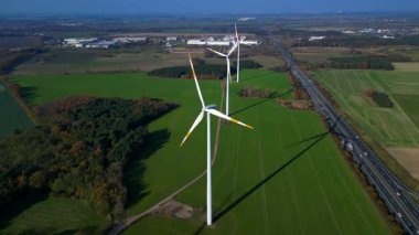 Alman otobanının yanındaki yeşil alanda duran rüzgar türbini yenilenebilir temiz yeşil eko enerji üretiyor. Hız rampası hiper hareket zaman aşımı ters uçuş panorama genel bakış İHA 'sı 