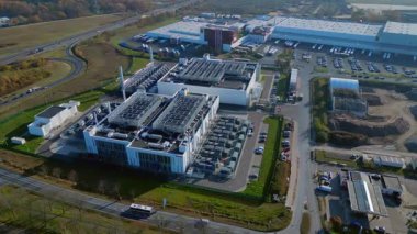 Modern veri merkezi endüstriyel bir alanda duruyor, dijital bilgi ve bağlantı sunuyor. İHA kamerası aşağıya bakıyor 