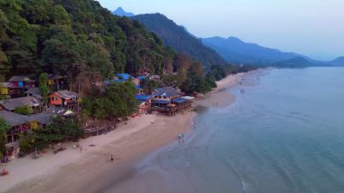 Koh Chang adasındaki beyaz kum plajı, turkuaz deniz kıyısındaki yeşil dağ ormanı. İticileri ileri çalıştır 
