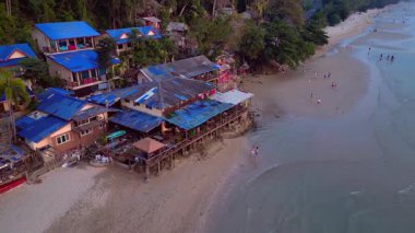 Koh Chang adasındaki beyaz kum plajı, turkuaz deniz kıyısındaki yeşil dağ ormanı. Yukarıdan drone atışı 