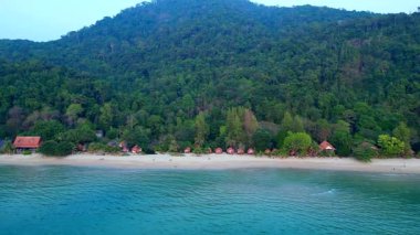 Kıyı boyunca bungalovları olan Koh Chang Tropikal plajı ve bir dağı kaplayan yoğun yeşil orman. İticileri ileri çalıştır 