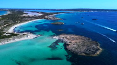 Formentera adasının ses Illetes plajı, sığ turkuaz deniz ve tekneleri. panorama genel görünüm dronu 