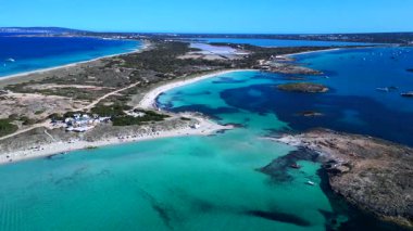 Formentera adasının ses Illetes plajı, sığ turkuaz deniz ve tekneleri. rotasyon tavası sol drona 