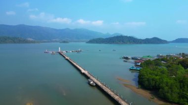 Kale, tekne ve tropik bir körfezde uzun bir rıhtım olan kıyı köyü. panorama genel görünüm dronu 