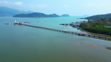 Kale, tekne ve tropik bir körfezde uzun bir rıhtım olan kıyı köyü. Uçarken üstten uçmak İHA 'yı ileri itmek 