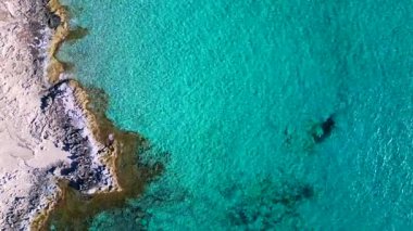 Formentera İbiza sahilinin saf turkuaz suyu ve denizin tadını çıkaran bireyler. dikey kuşların görüş dronu. statik üç ayaklı insansız hava aracı 