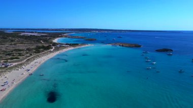 Balear Adaları 'ndaki kumlu bir sahil şeridi yakınlarında kristal berrak sularda yüzen sayısız lüks yat ve tekne. panorama genel görünüm dönüş panosu sağ drone 'a 