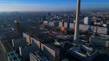 Berlin şehir manzarası, Red Town Hall 'daki hareketli bir Noel pazarının üzerinde yükselen TV kulesi. statik tripod yukarıdan drone atışı yapıyor. 