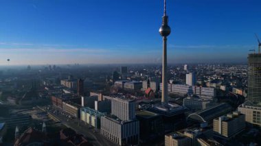 Berlin şehir manzarası, Red Town Hall 'daki hareketli bir Noel pazarının üzerinde yükselen TV kulesi. Sinek ileri itme panorama genel görünüm drone 