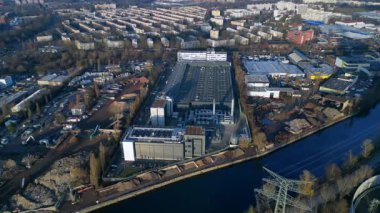 Berlin 'in kentsel manzarasındaki bir nehrin yanında dijital dönüşümü destekleyen modern veri merkezi tesisi. Yukarıdan aşağıya drone görünümü