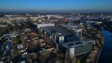 Berlin 'in kentsel manzarasındaki bir nehrin yanında dijital dönüşümü destekleyen modern veri merkezi tesisi. Drone görüntülerini daire içine al