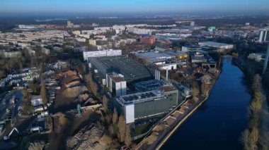 Berlin 'in kentsel manzarasındaki bir nehrin yanında dijital dönüşümü destekleyen modern veri merkezi tesisi. geniş yörünge görünümü dronu