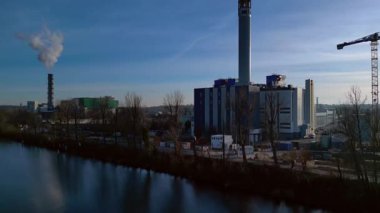 Açık mavi gökyüzüne buhar yayan, sürdürülebilir kentsel gelişimi gösteren büyük bacaların yer aldığı kentsel atıklardan enerji santraline. İHA hız rampası yükseltiliyor Hiper hareket süresi doluyor
