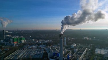 Açık mavi gökyüzüne buhar yayan, sürdürülebilir kentsel gelişimi gösteren büyük bacaların yer aldığı kentsel atıklardan enerji santraline. panorama genel görünüm dronu yükseliyor