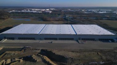 Yeni Mobil robotlar birçok yükleme rıhtımına sahip tam otomatik büyük modern dağıtım lojistik merkezi. İticileri ileri çalıştır
