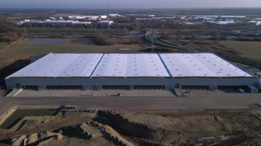 Yeni Mobil robotlar birçok yükleme rıhtımına sahip tam otomatik büyük modern dağıtım lojistik merkezi. panorama genel görünüm dronu