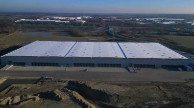 Yeni Mobil robotlar birçok yükleme rıhtımına sahip tam otomatik büyük modern dağıtım lojistik merkezi. panorama genel görünüm dronu
