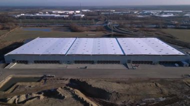 Yeni büyük lojistik merkezi inşaatı devam ediyor. Geniş bir depolama alanı, yükleme limanları ve çevresindeki boş araziler var. Hız rampası hiper hareket zamanı hızlandırılmış panorama yörünge dronu