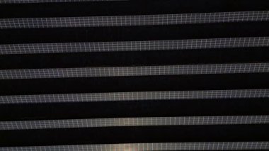 Havadan bakıldığında, sürdürülebilirlik ve çevre dostu güç için yeşil elektrik üreten büyük fotovoltaik güneş panelleri. dikey kuşların göz teması uçuş üstü insansız hava aracı